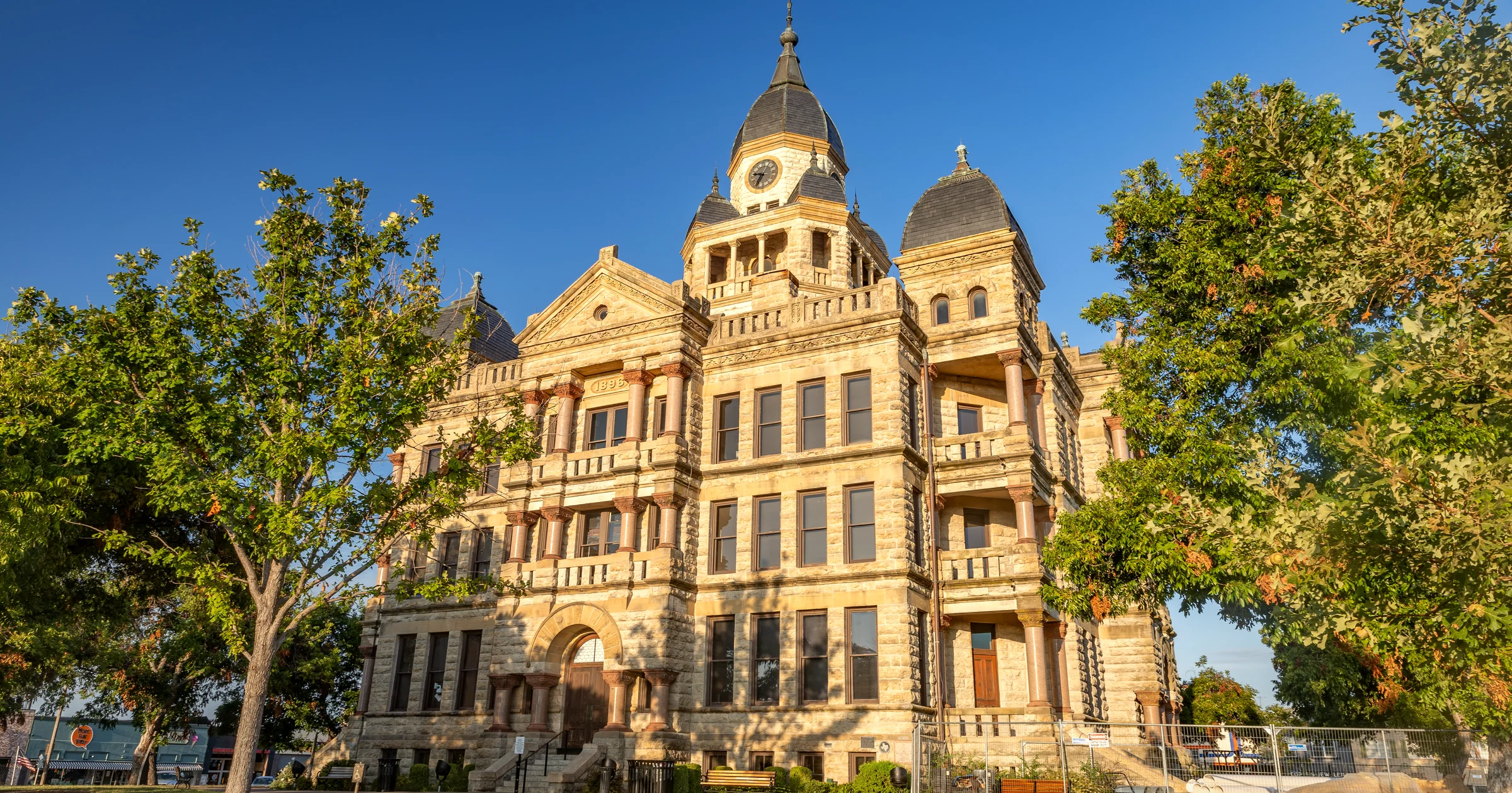 The 1896 Denton County Courthouse-on-the-Square in Denton, Texas, framed by green trees under a blue sky